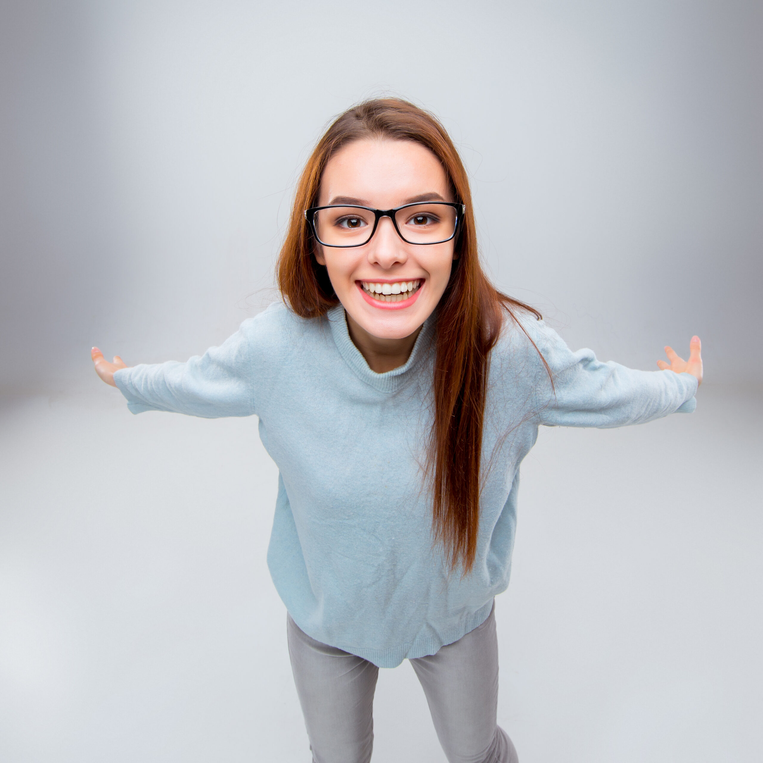 Smiling young business woman in glasses on a gray background. Top view